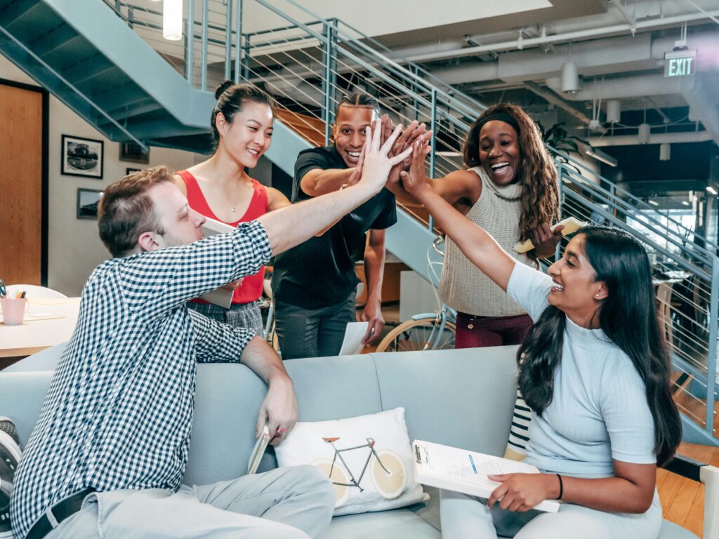 Image of workplace colleagues cheering the success of the company.